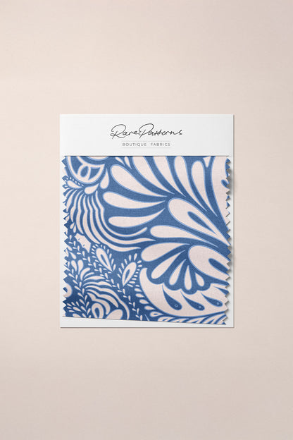 Packaging of fabric with blue and white paisley pattern on a neutral background